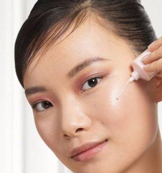 a woman applying makeup on her face