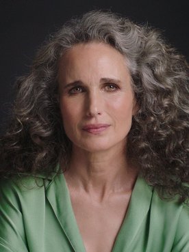 Portrait photo of Andie MacDowell in front of black background.