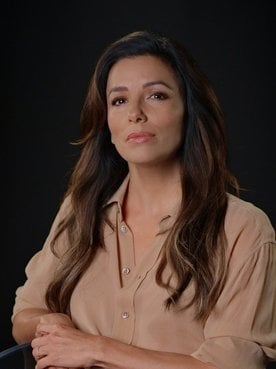 Portrait photo of Eva Longoria in front of black background.
