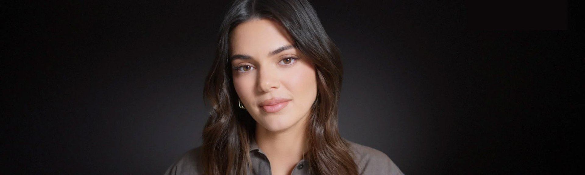 Portrait photo of Kendall Jenner in front of black background.