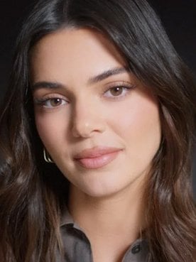 Portrait photo of Kendall Jenner in front of black background.